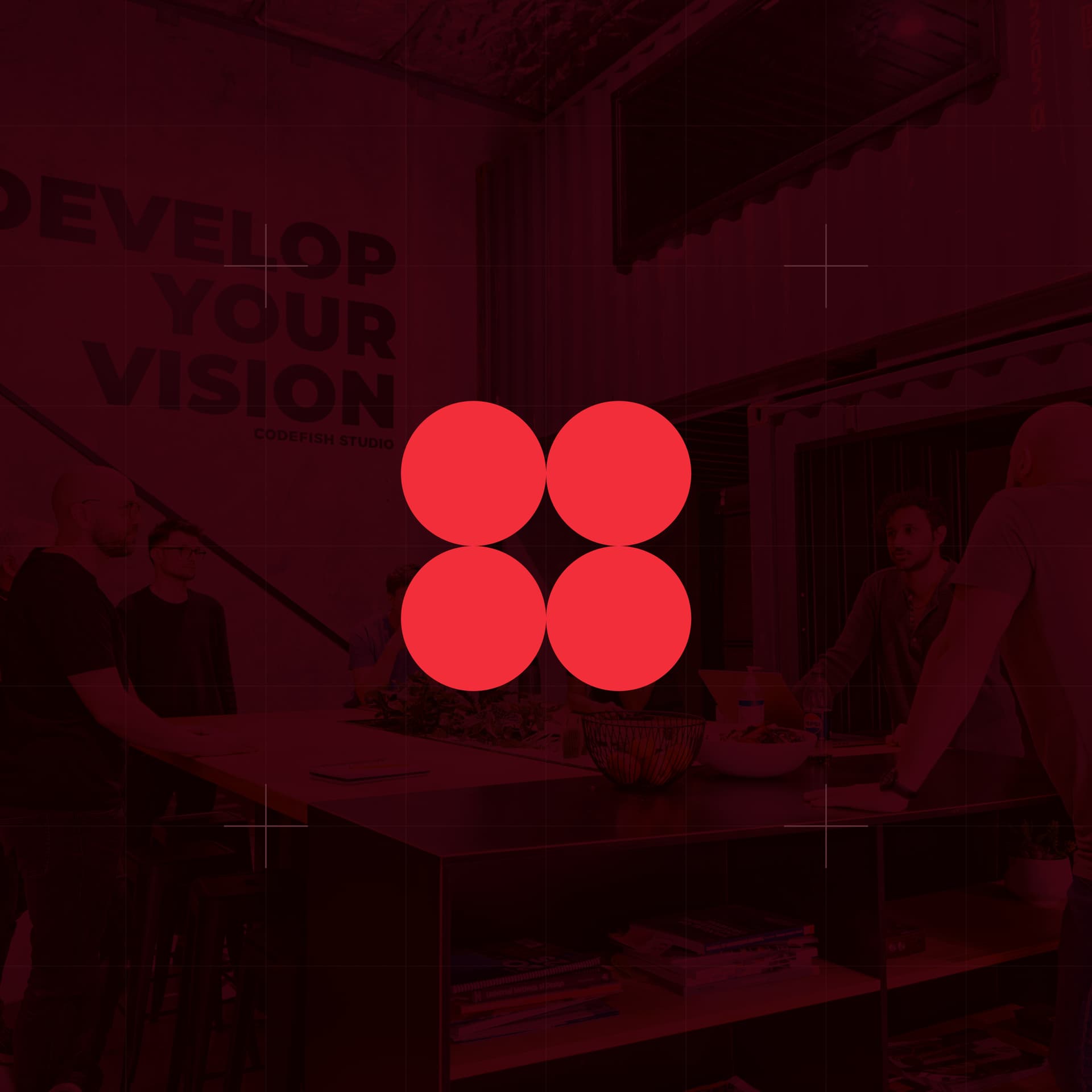 CodeFish Studio four-dot glyph over a red-tinted studio scene with a Develop Your Vision wall