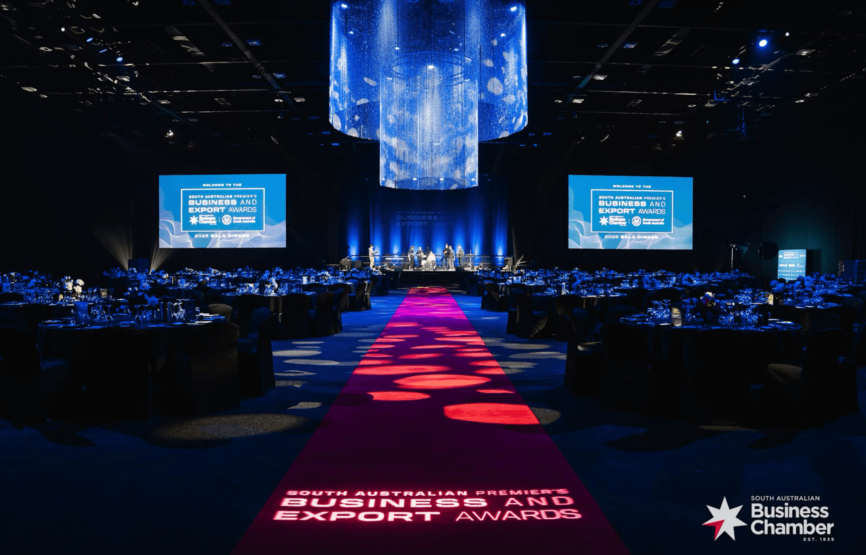 The Business and Export Awards gala room with a lit red carpet, stage and banquet tables